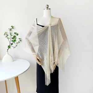 Detail of elegant champagne gold metallic mesh shawl featuring long fringe and knotted draping