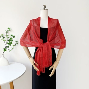 Detailed macro view of the vibrant red metallic mesh shawl with fine fringe tassels