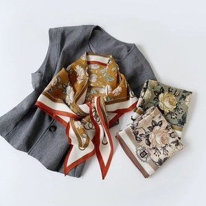 Detail of vintage floral and equestrian chain patterns on silky satin triangle scarves