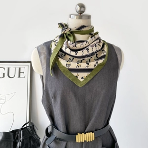 Detail showing high-quality silk scarf with classic horse prints on a mannequin