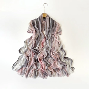Detail shot of lightweight gradient scarf with crinkled texture and soft tassel fringe