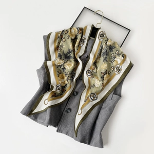Detail of vintage French pattern silk scarf paired with a grey vest on a hanger