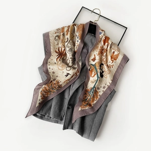 Détail d'un foulard floral drapé sur un gilet de costume gris sur fond blanc immaculé