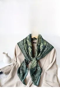 Detail of vintage dark green paisley scarf draped over an apricot blazer for luxury styling