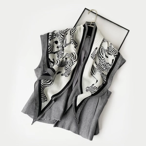 Detail eines Seidenschals mit Zebramuster an einer grauen Weste für einen modischen Look