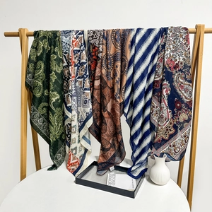 Detail view of five assorted lightweight shawls with paisley and ethnic prints on a rack