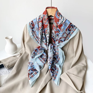 Detailed shot of retro paisley pattern scarf paired with a stylish khaki blazer