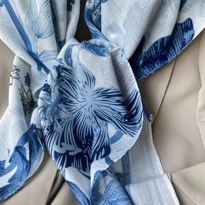 Close-up of blue botanical pattern on lightweight cotton linen scarf with natural fabric texture