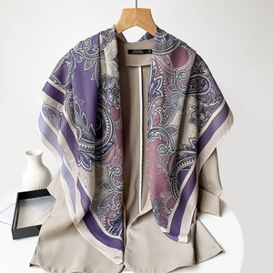 Detailed macro view of lightweight paisley print silk scarf with purple border