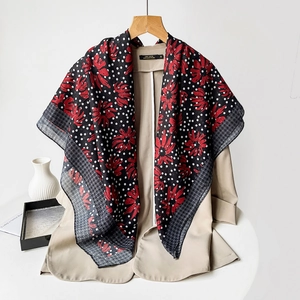 Detail of floral paisley silk scarf with polka dots draped on a khaki blazer