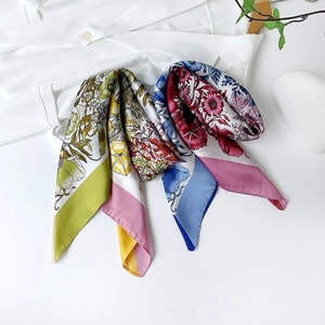 Detailed flat lay of 90cm satin silk scarves with elegant floral prints and soft textures