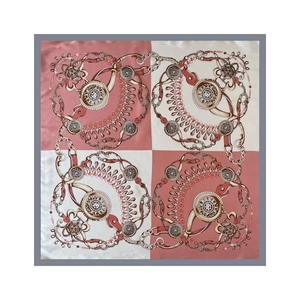 Dettaglio di foulard in seta rosa e beige con motivi equestri di catene e staffe fini
