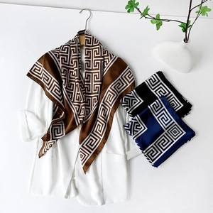 Détail d'un foulard en satin de soie avec motifs grecs en marron, noir et bleu