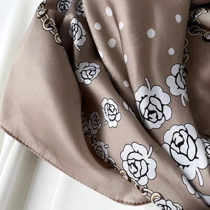Dettaglio foulard in raso color moka con rose bianche, pois e catene dorate