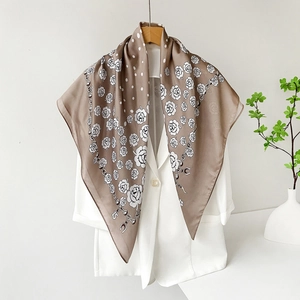 Elegante sciarpa di raso marrone con motivi di rose e catene su una gruccia di legno
