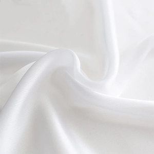 Détail macro du tissu en soie blanche douce avec texture drapée élégante et éclat soyeux