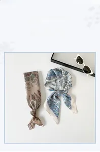 Détail de foulards en soie à imprimé paisley rose et bleu avec une finition satinée