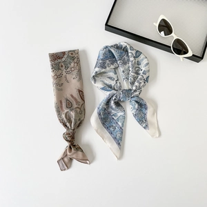 Gros plan de foulards en soie à imprimé paisley montrant la texture satinée et les motifs
