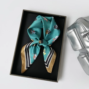 Detailansicht eines Seidenschals mit französischen Bulldoggen-Mustern in einer Geschenkbox
