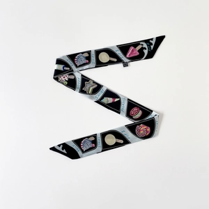Détail d'un foulard en soie avec imprimés géométriques et motifs de dessins animés