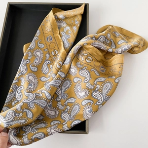 Detail eines gelben Paisley-Seidentuchs mit weicher Textur und elegantem Muster