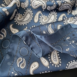 Nahaufnahme des tiefblauen Seidentuchs mit Paisleymuster und feiner Saumverarbeitung