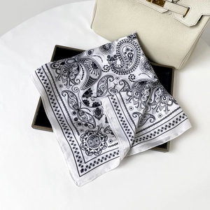 Detail of paisley pattern silk scarf elegantly placed on a tray with satin texture