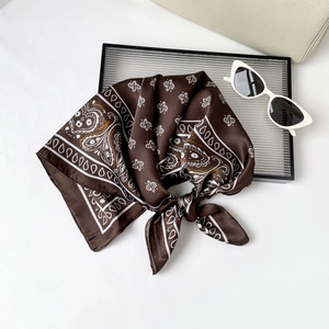 Detail of elegant dark brown paisley satin silk scarf with intricate geometric patterns