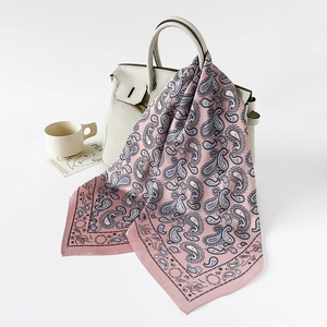 Rosafarbenes Seiden-Halstuch mit Paisley-Muster an einer eleganten Handtasche
