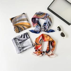 Primo piano di quattro foulard in seta con eleganti motivi geometrici e astratti
