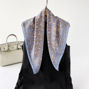 Detail eines hellblauen Paisley-Seidenschals mit klassischem Muster und weichem Fall