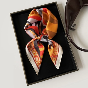 Dettaglio del foulard satinato con stampa geometrica in vassoio con borsa elegante