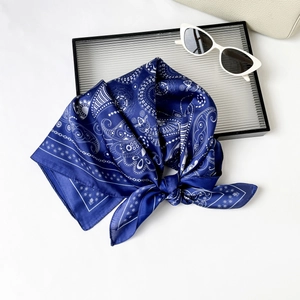 Detailed view of dark blue paisley silk scarf with bohemian mandala patterns on white bag