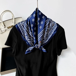 Navy blue paisley silk scarf tied in a stylish knot on a black short sleeve shirt