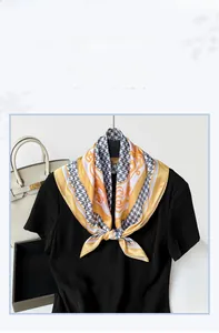 Detail of silk-feel houndstooth scarf with yellow baroque patterns on a black top
