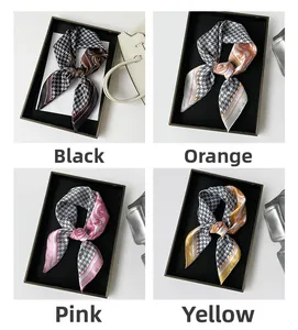 Detail view of houndstooth silk scarves in black, orange, pink, and yellow color options