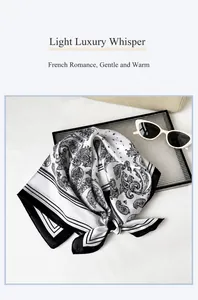 Dettaglio del foulard in raso bianco e nero con motivo paisley e bordi a righe