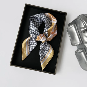 Detail of silk square scarf featuring black houndstooth and golden baroque patterns