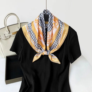 Classic houndstooth and baroque print silk scarf tied elegantly around a neck