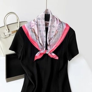 Detailed shot of a pink and white four-leaf clover print satin scarf on a black dress