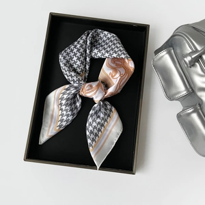 Close-up of silk square scarf with houndstooth and baroque patterns in a premium gift box