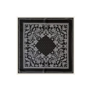 Dettaglio di un foulard in raso con motivi paisley bianchi su tessuto nero liscio