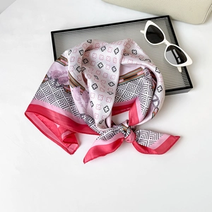Close-up of elegant pink clover print satin scarf styled with fashion accessories