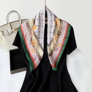 Detailed close-up of elegant satin scarf with vintage buckle print and chain motifs