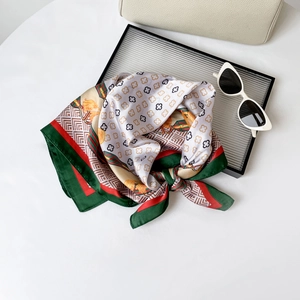 Detailed close-up of clover buckle pattern on a silky scarf with red and green stripes