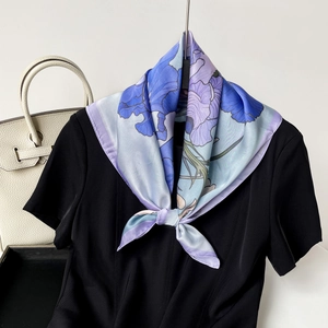 Detail of floral silk scarf with iris print styled on a black shirt for a French look