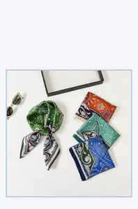 Macro detail of paisley satin silk scarves in green, orange and blue with elegant glossy texture