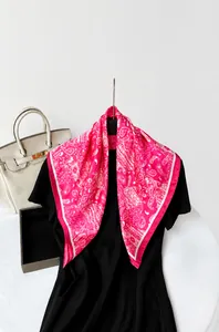 Close-up of fuchsia satin square scarf featuring detailed white paisley floral patterns