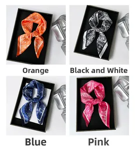 Macro detail of satin neck scarves in orange, black, blue and pink with paisley patterns
