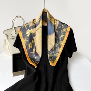 Detail of oil painting floral silk scarf draped over a black dress with luxury bag nearby